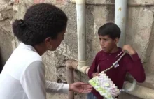Wenezuelski chłopiec szyje sobie torbę z banknotów