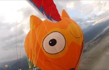 Paralotniarze latający pomiędzy balonami na ogrzane powietrze