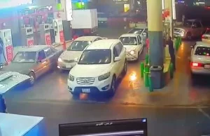 Grupa śmiałków gasi płonący samochód na stacji benzynowej