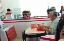 Staruszek ze zdjęciem żony w restauracji