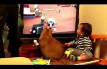 Kot razem z dzieckiem, ogląda materiał wideo na telewizorze...