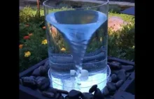 Wielka szklanka z wirem wodnym w ogródku.