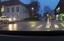 Mężczyzna pomaga starszej pani przejść przez ulicę