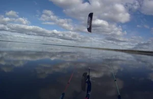 Kitesurfing na idealnie gładkiej tafli jeziora.