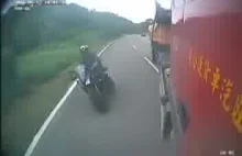 Motocyklista wyprzedza ciężarówkę na zakręcie [18+]