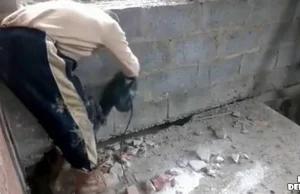 Rosyjski robotnik rozkuwa podłogę na której sam stoi.