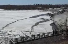 Pokrywa lodowa płynąca z nurtem rzeki kruszy się przed wodospadem