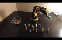 Robot zbiera ze stołu figurki gumowe