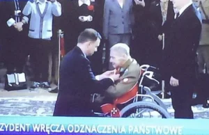 Prezydent klęczy odznaczając gen. Gryfa, bohatera z Pałacu Michla