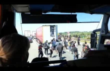 Afrykańscy imigranci szturmujący port Calais widziani z autokaru.