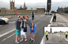 Ludzie robią selfie przy kordonach policji w zwiazku z zamachem.