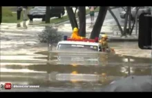 Wóz strażacki przejeżdża przez zalaną drogę