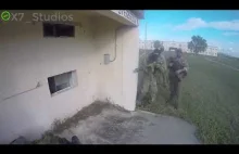 Żołnierz wrzuca granat przez okienko.