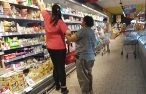 Pracownica Polomarketu pomaga niepełnosprawnej klientce w zakupach