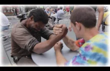 Dwóch bezdomnych siłuje się na rękę za pieniądze