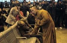 Mnich modli się za zmarłego, na stacji kolejowej