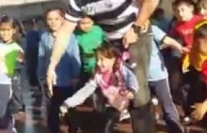 Nauczyciel wf-u pomaga niepełnosprawnej dziewczynce dołączyć do tańca