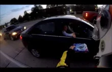 Motocyklista częstuje ciasteczkiem panią z samochodu