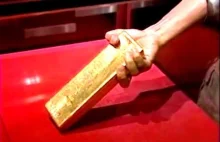 Wyciąganie sztabki złota ze szklanej gabloty