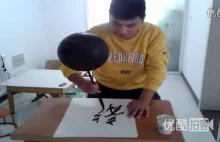 Chińczyk kręcący piłką na pędzlu podczas kaligrafii