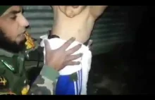 Iracki żołnierz zdejmuje pas szahida z ciała kilkuletniego chłopca