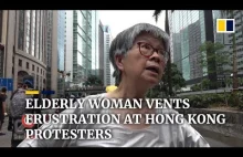 Starsza kobieta próbuje uprzątnąć ulicę w Hong Kongu.