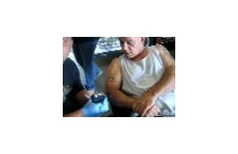 Usuwanie tatuażu za pomocą szlifierki u mechanika.