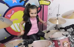 6-latka gra Slipknota na różowej perkusji