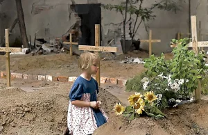 Dziewczynka klęcząca przy grobie