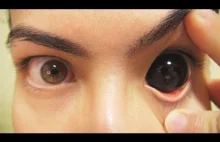 Zakładanie czarnych soczewek pokrywających całe oko.
