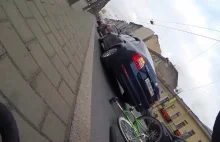 Rowerzysta upuszcza telefon na ulicy.