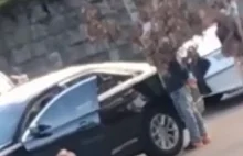 Małe dziecko wysiada z auta z podniesionymi rękoma