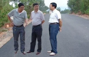 Chińscy urzędnicy w służbie partii z dumą wizytują nowo wybudowaną drogę.