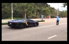 Mężczyzna rzuca kamieniem w lamborgini Aventador.