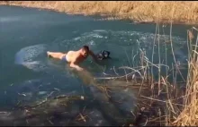 Człowiek pogrąża się w zamarzniętej rzece, aby ratować tonącego psa