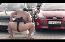 Zawodnicy sumo vs ciasny parking przed supermarketem