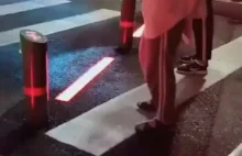 Chińskie przejścia dla pieszych z laserami i parą tryskającą na czerwonym.