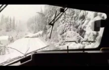 Jazda pociągiem po zaśnieżonym torowisku i po powalonych drzewach przez śnieg