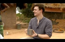 Mateusz Damięcki w Ghanie pomaga kobiecie nieść wodę.