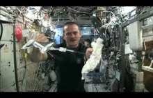 Astronauta wyciska mokry ręcznik w kosmosie