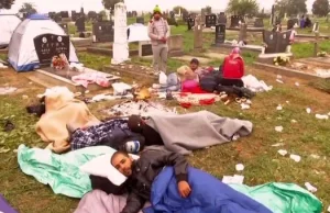 Imigranci obozują na cmentarzu. Muzyka, ogniska i spanie na grobach (video