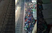 Pasażerowie próbujący wsiadać i wysiadać z indyjskiego pociągu