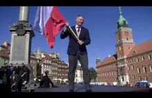 Przemysław Wipler z flagą Polski pozuje do zdjęć